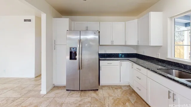 a kitchen with a refrigerator and white cabinets