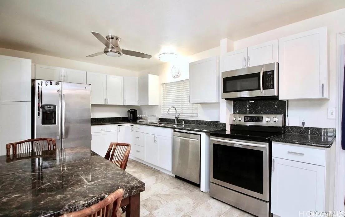 85-059 Waianae Valley Road Waianae, HI 96792 - Photo 7 of 20 a kitchen with kitchen island granite countertop a stove sink microwave and refrigerator