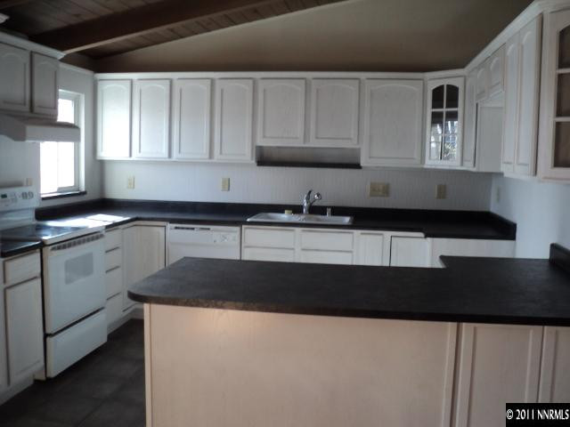 740 Reeves Avenue Reno, NV 89503 - Photo 3 of 9 a kitchen with granite countertop a sink a stove and cabinets