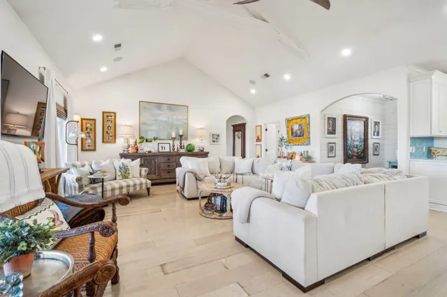 a living room with furniture kitchen view and a large window