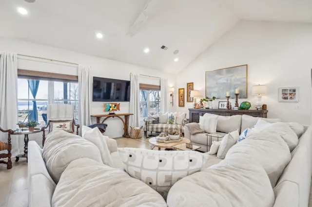 a spacious bedroom with a bed a flat screen tv and windows