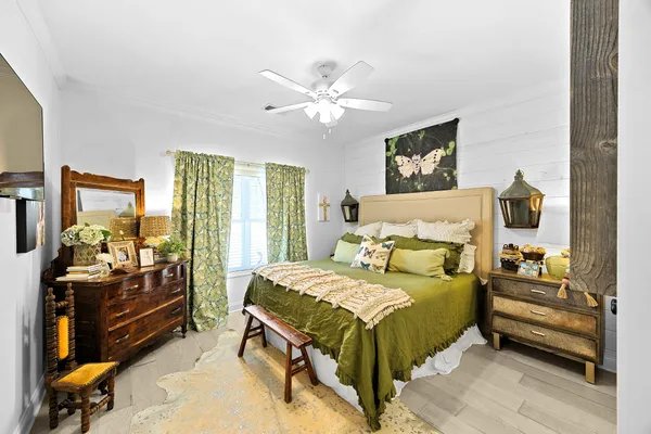 a bedroom with a bed and wooden floor