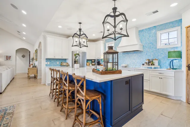 a large kitchen with kitchen island a sink a stove and a wooden floors