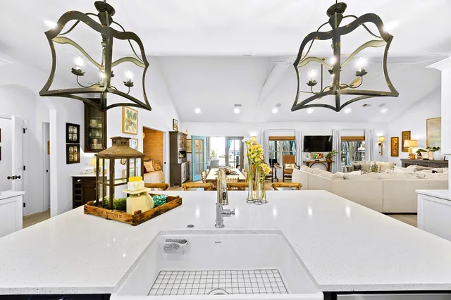 a dining hall with stainless steel appliances lots of white furniture a dining table and chairs