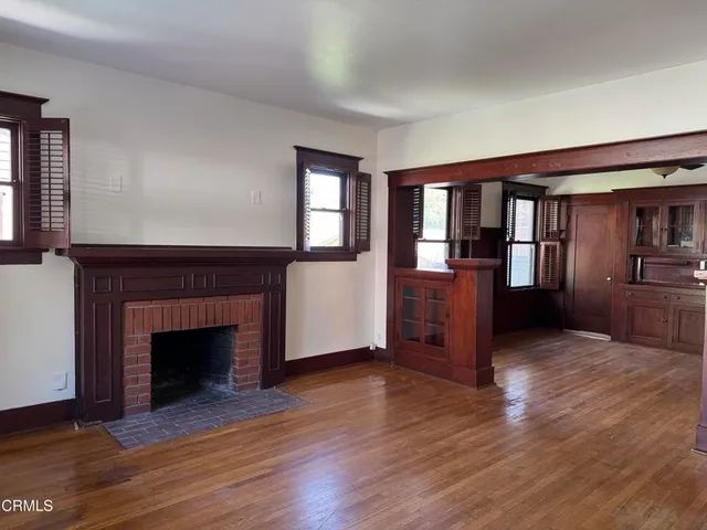 a kitchen with stainless steel appliances granite countertop a refrigerator a sink dishwasher a stove and a dining table with wooden floor