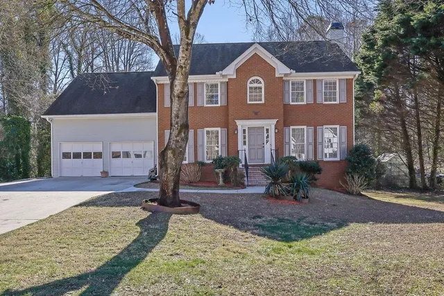 a dining room with furniture potted plants and wooden floor