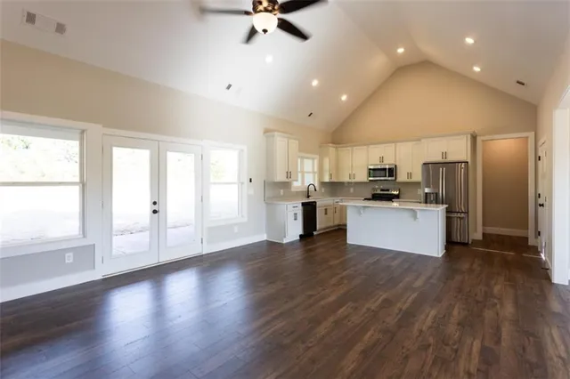 a view of kitchen with cabinets stainless steel appliances wooden floor and window