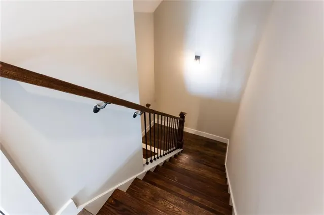 an empty room with wooden floor and chandelier