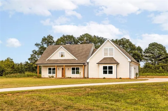 a view of a big house with a big yard and large trees