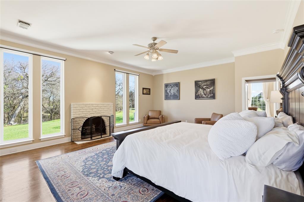 243 South King Road Heath, TX 75126 - Photo 23 of 40 a spacious bedroom with a balcony a bed and a fireplace