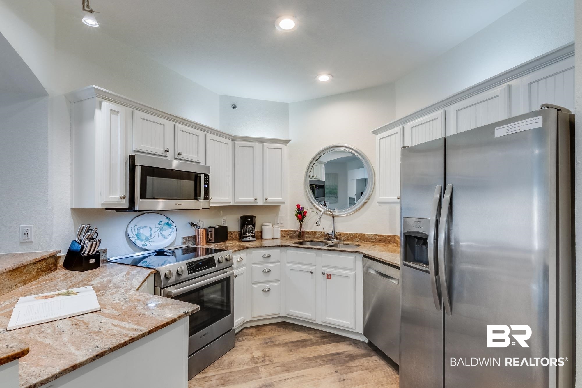 20050 Oak Road East Gulf Shores, AL 36542 - Photo 3 of 14 Kitchen with stainless steel appliances, light stone counters, light wood-style flooring, white cabinetry, and recessed lighting