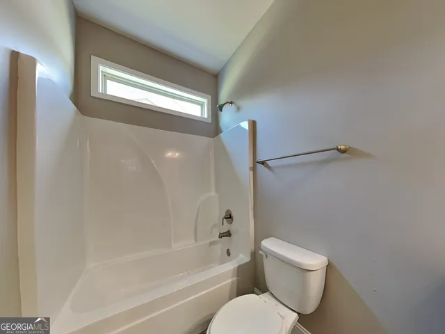 a view of a hallway with a livingroom and a window