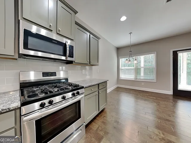 a kitchen with stainless steel appliances granite countertop a stove microwave and sink