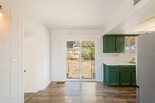a view of a kitchen with wooden floor and a kitchen space