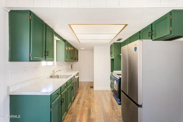 a bathroom with a sink a mirror and a refrigerator