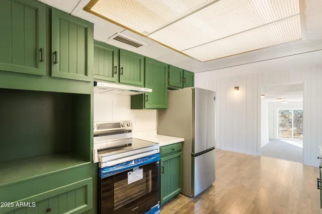 a kitchen with a refrigerator and a stove top oven