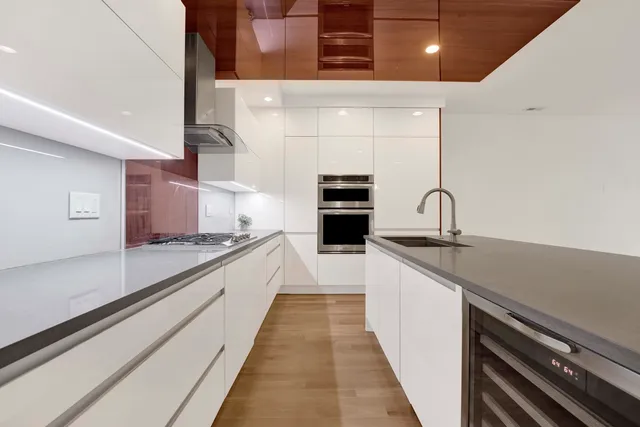 a large kitchen with stainless steel appliances a sink and cabinets