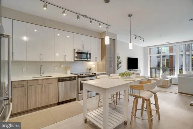 a large kitchen with kitchen island a sink table and chairs