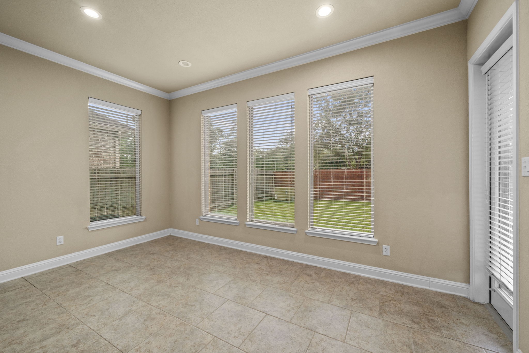 14215 Spindle Arbor Road Cypress, TX 77429 - Photo 29 of 47 Bright room with large windows, tile flooring, and neutral walls, offering a view of a private backyard.