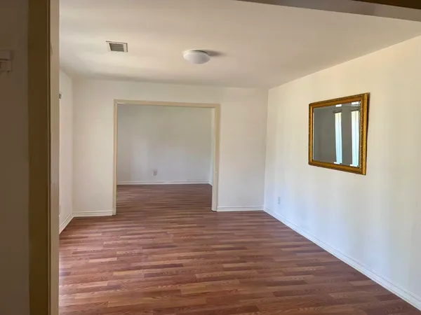 a view of an empty room with wooden floor