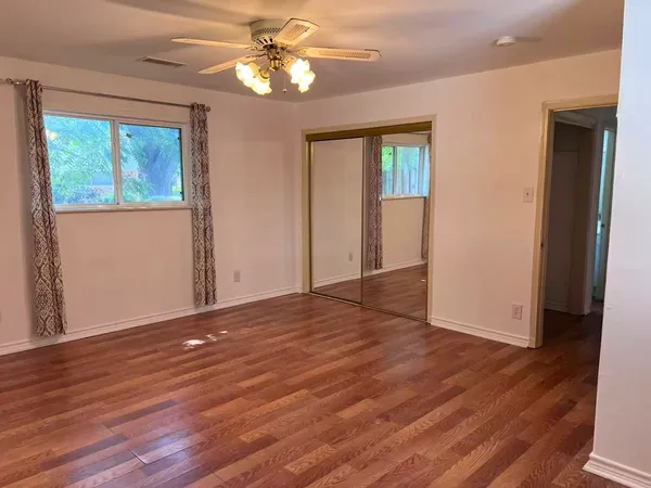 a view of empty room with wooden floor