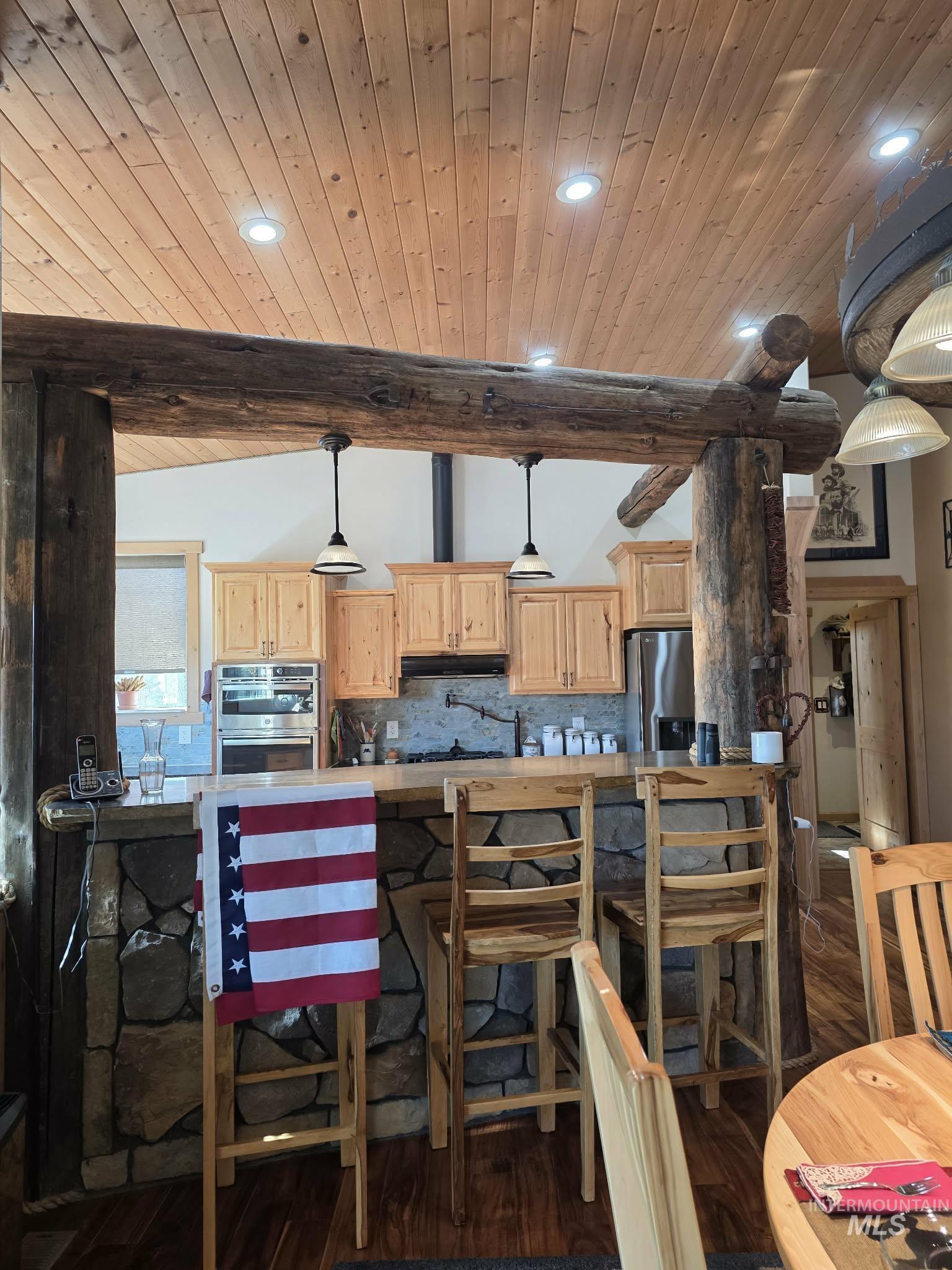 809 River Pointe Lane Lenore, ID 83541 - Photo 16 of 43 Kitchen with light wood finish cabinets, tasteful backsplash, hanging light fixtures, light countertops, and a wooden ceiling with exposed beams