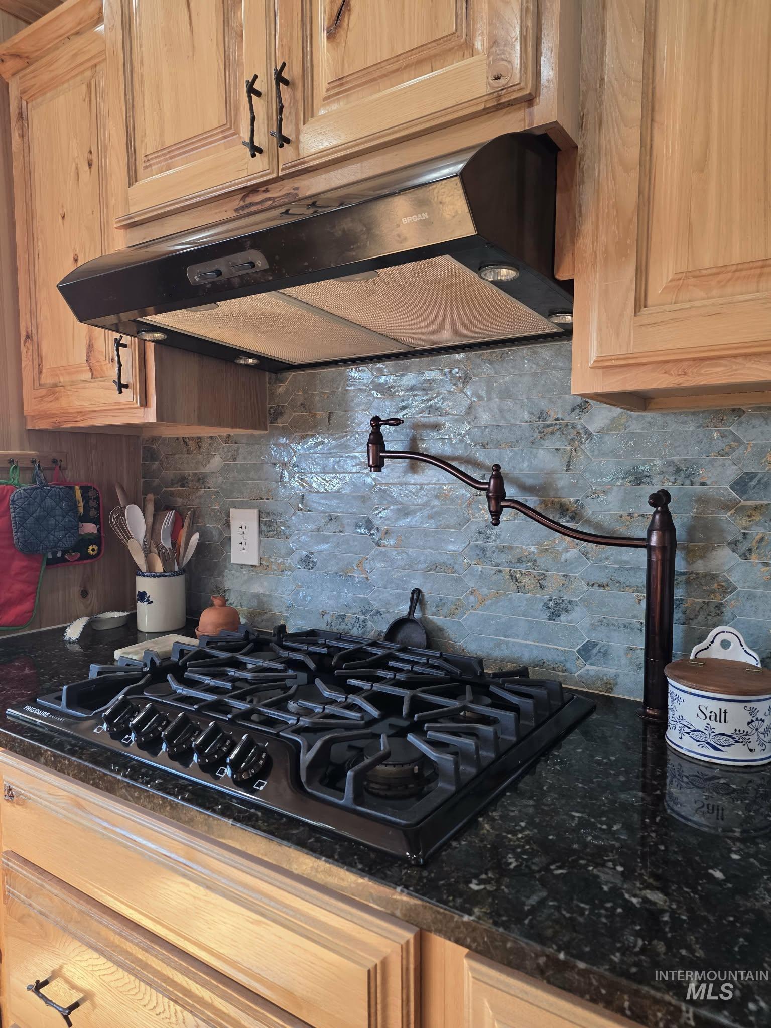 809 River Pointe Lane Lenore, ID 83541 - Photo 20 of 43 Kitchen view of black gas stovetop, pot filler, light wood finish cabinetry, and tasteful backsplash