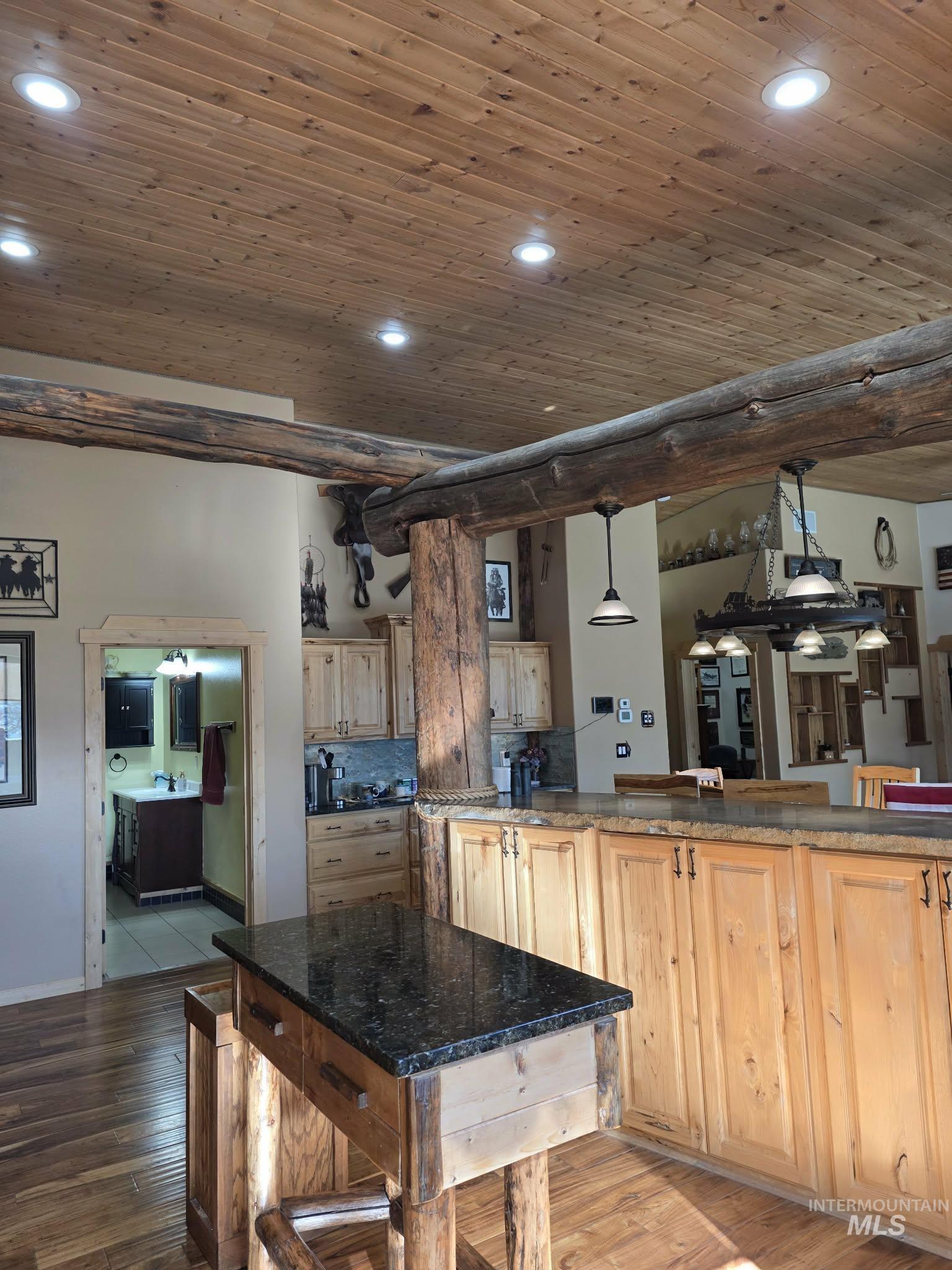809 River Pointe Lane Lenore, ID 83541 - Photo 21 of 43 Kitchen featuring wooden ceiling, light wood finish cabinets, light wood-type flooring, pendant lighting, and a kitchen breakfast bar