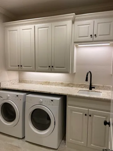 a utility room with sink dryer and washer