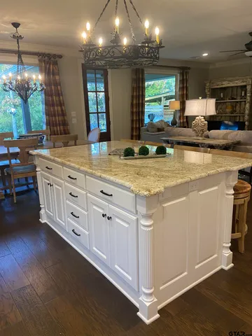 a view of a kitchen counter space with wooden floor and staircase