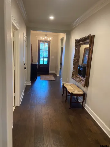 a view of a hallway with wooden floor and furniture