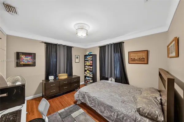 a bedroom with a large bed and a flat tv screen on dresser