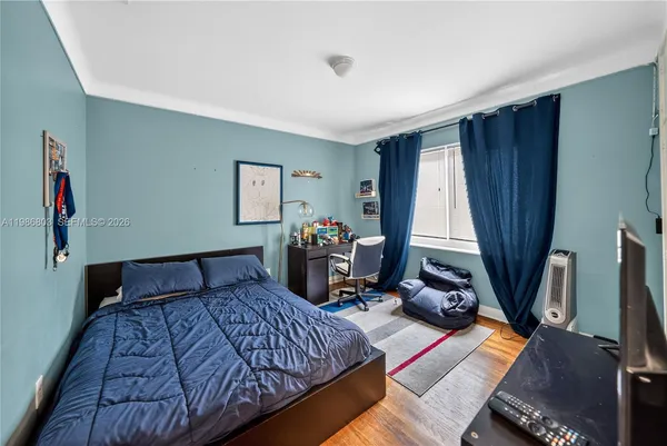 a bedroom with bed and a flat tv screen