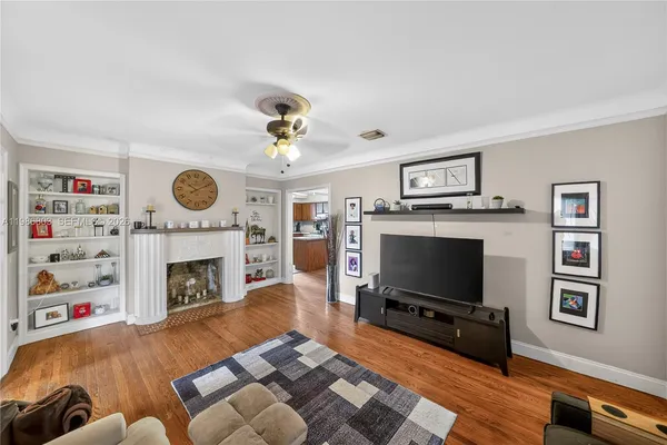 a living room with furniture a flat screen tv and a fireplace