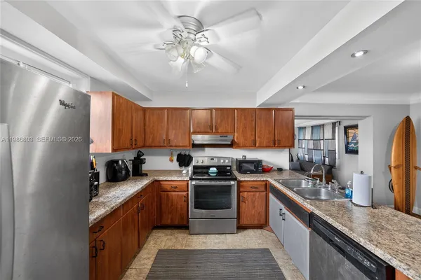 a kitchen with stainless steel appliances granite countertop a sink a stove and refrigerator