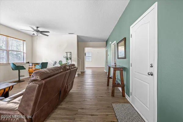 a dining hall with stainless steel appliances granite countertop a stove and a wooden floors