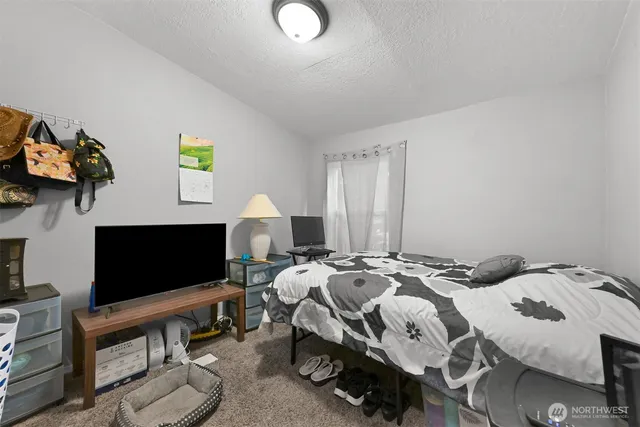 a bedroom with bed and a flat screen tv