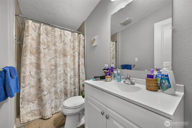 a bathroom with a sink a toilet and a mirror