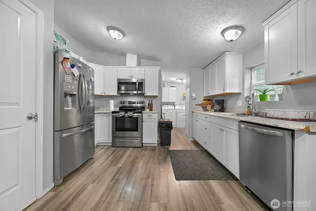 a kitchen with granite countertop stainless steel appliances a refrigerator sink and microwave