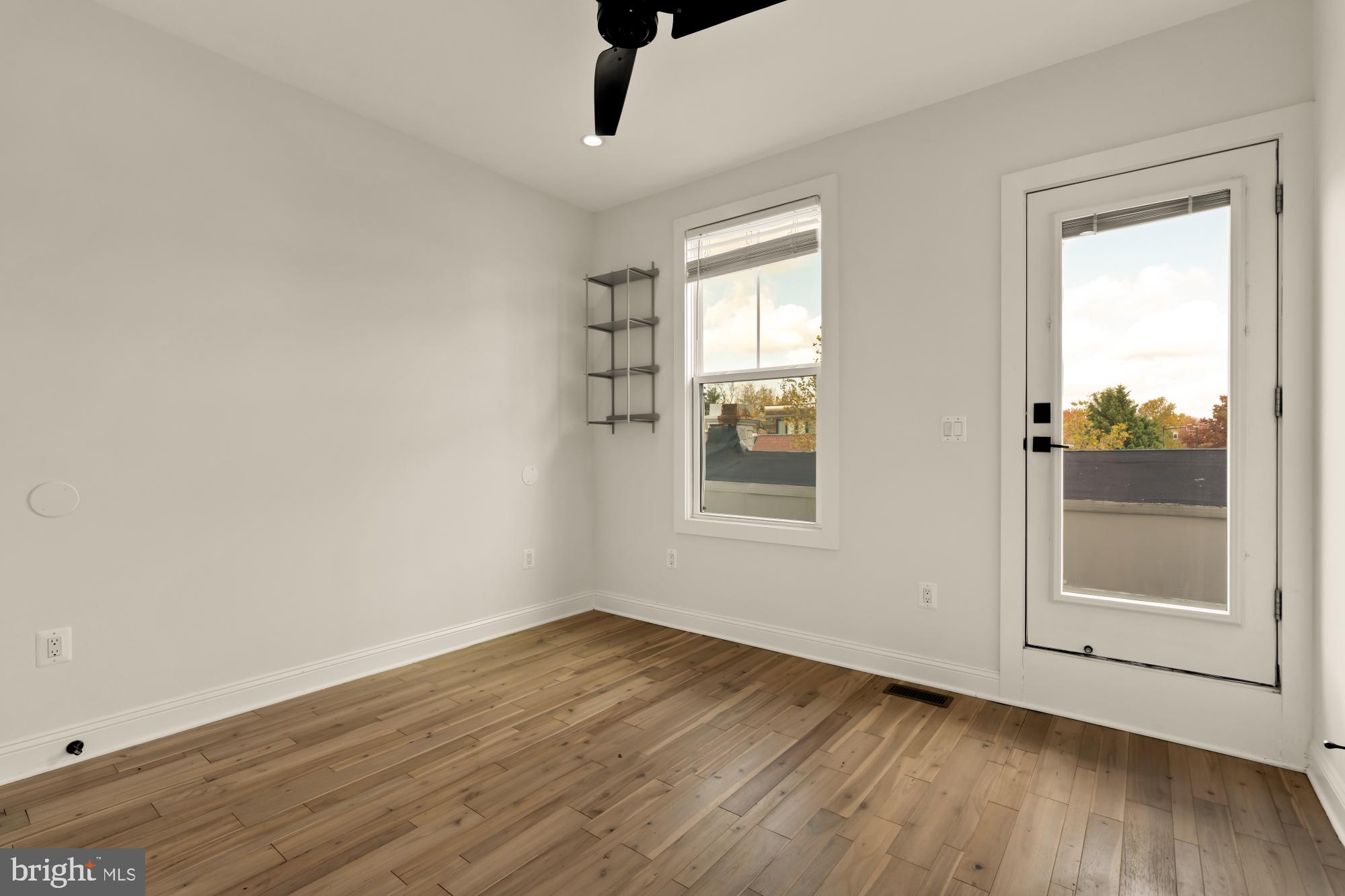 1310 Spring Road Northwest, Unit PHB Washington, DC 20010 - Photo 15 of 18 an empty room with wooden floor and windows