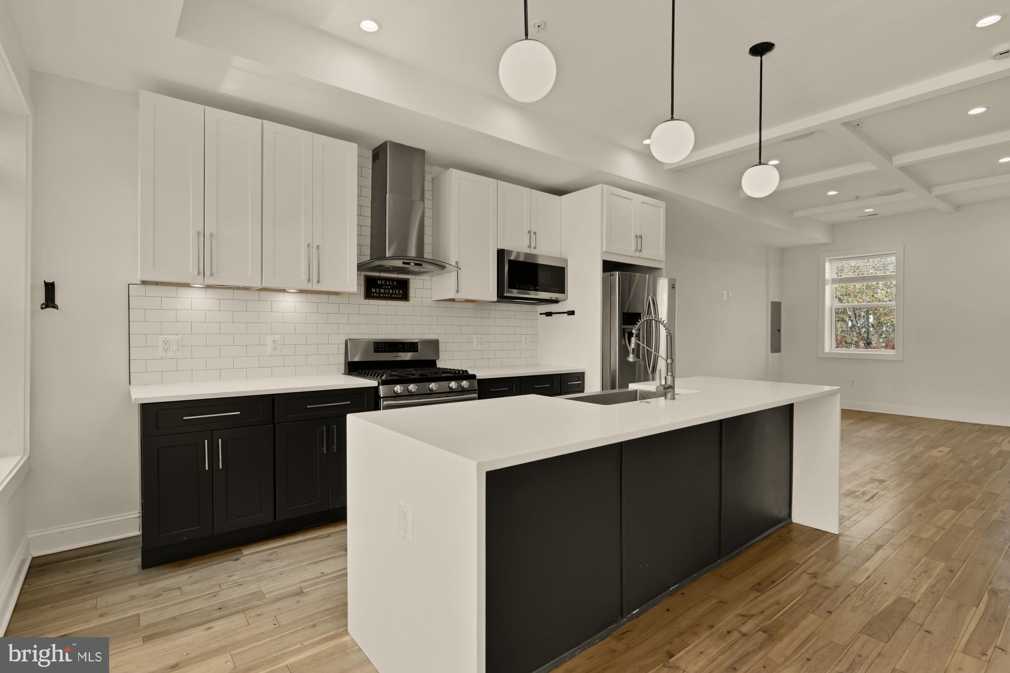 1310 Spring Road Northwest, Unit PHB Washington, DC 20010 - Photo 4 of 18 a kitchen with a sink stainless steel appliances and wooden floor