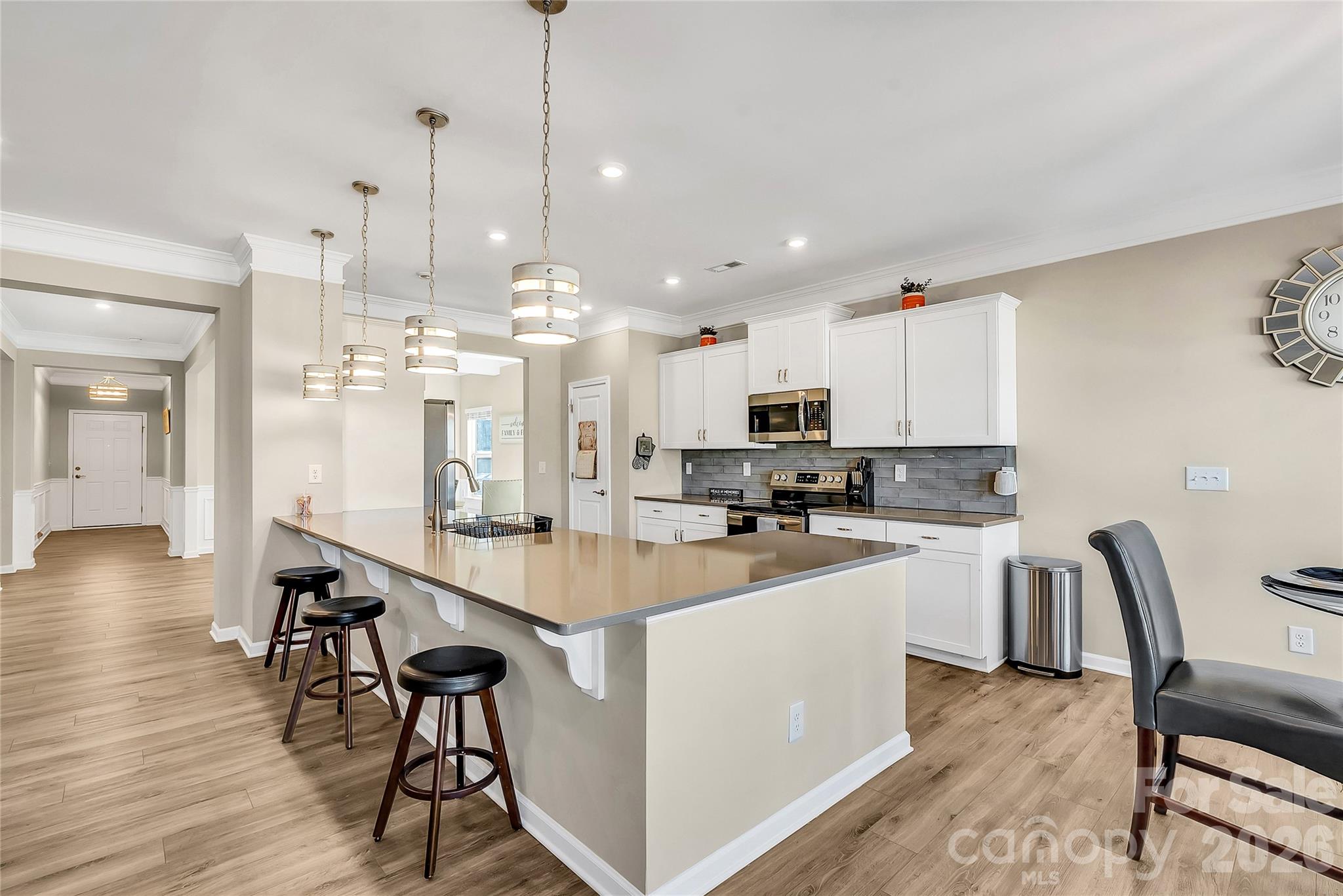 14421 Holbrooks Road Huntersville, NC 28078 - Photo 3 of 29 a kitchen with kitchen island a stove a table a sink a refrigerator and cabinets
