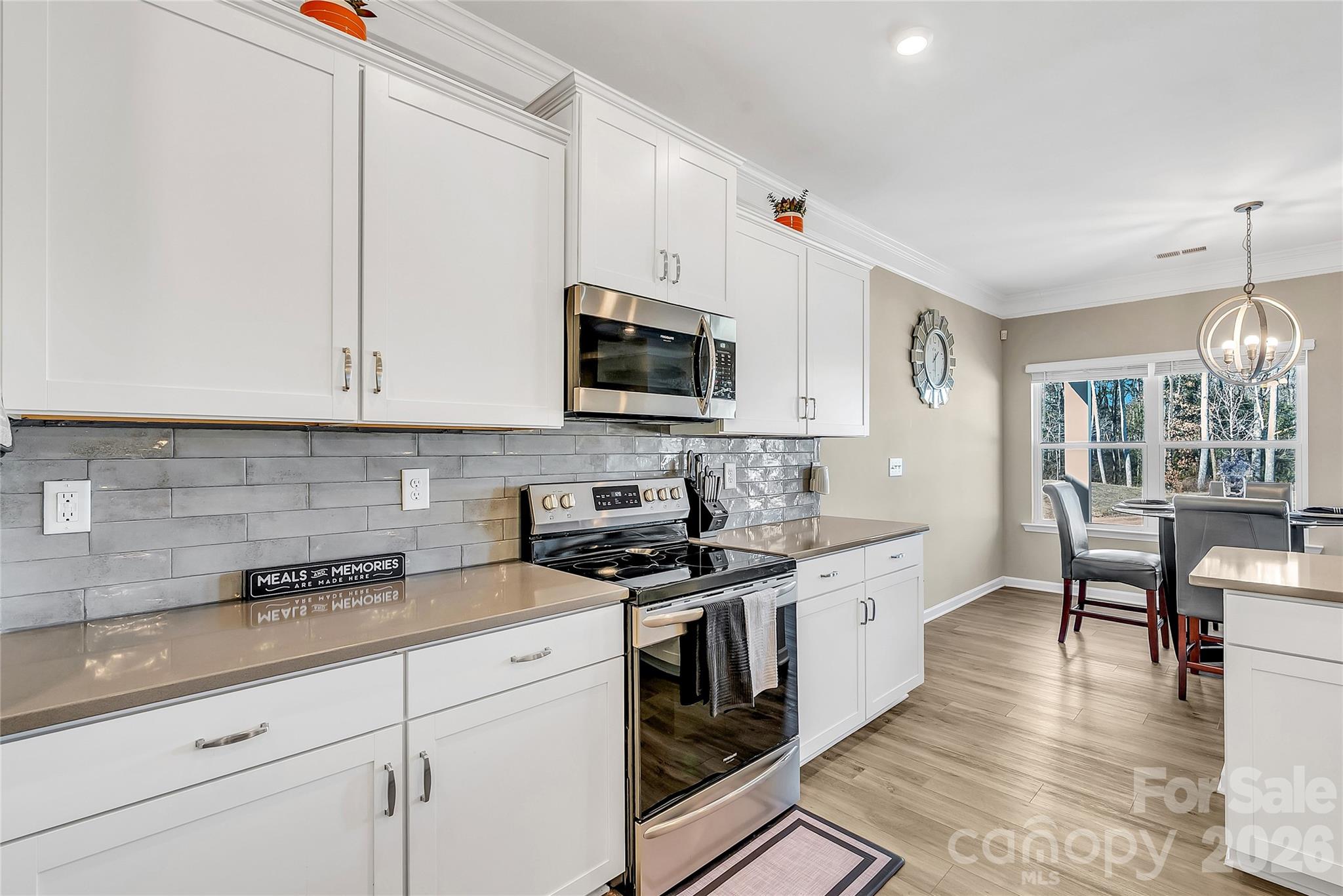 14421 Holbrooks Road Huntersville, NC 28078 - Photo 4 of 29 a kitchen with stainless steel appliances granite countertop a stove a sink and white cabinets