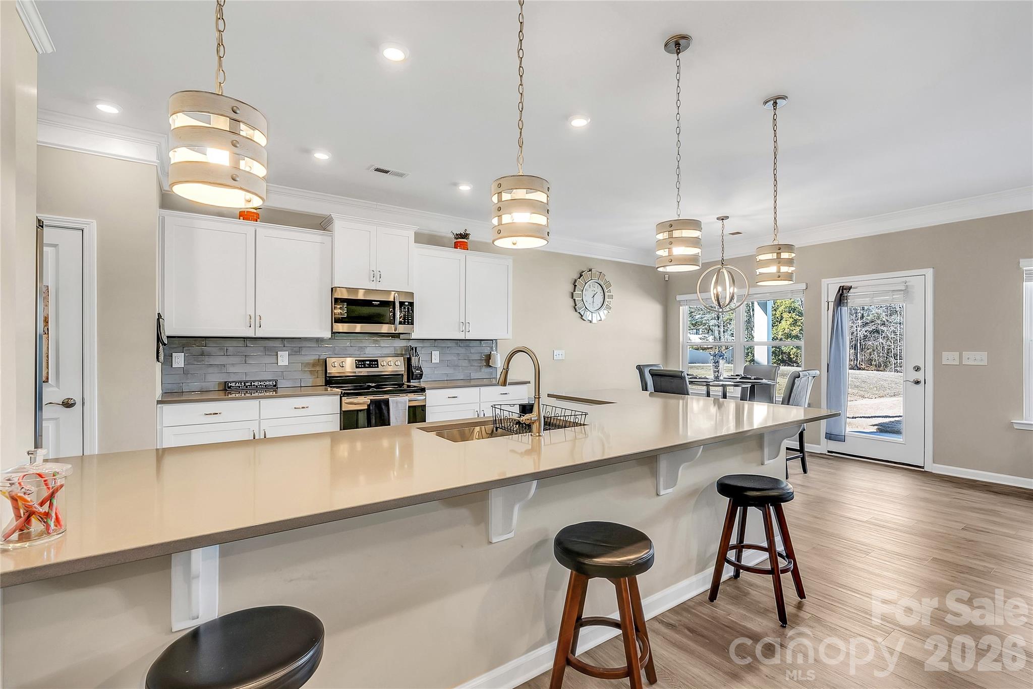 14421 Holbrooks Road Huntersville, NC 28078 - Photo 6 of 29 a large kitchen with granite countertop lots of counter space dining table and stainless steel appliances