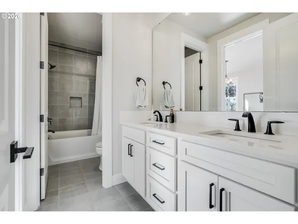 a bath room with a sink double vanity tub and a shower