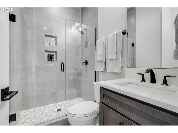 a bathroom with a sink toilet double vanity and shower