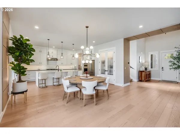 a view of a dining room and livingroom with furniture wooden floor a chandelier