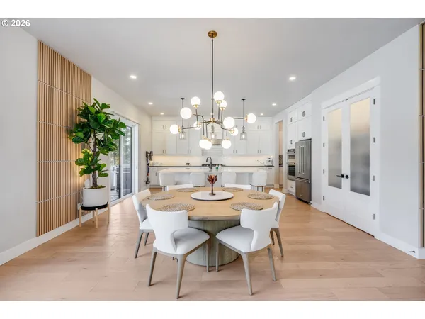 a dining room with furniture a chandelier and wooden floor