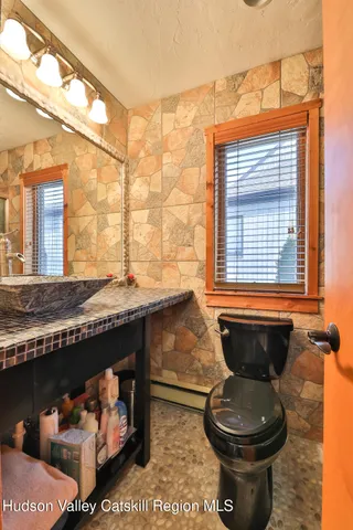 a bathroom with a granite countertop sink and a toilet