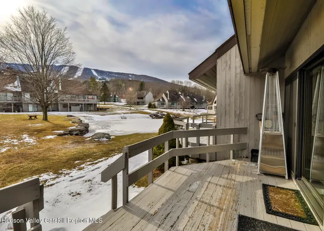 a view of a patio with table and chairs barbeque potted plants with wooden floor and fence